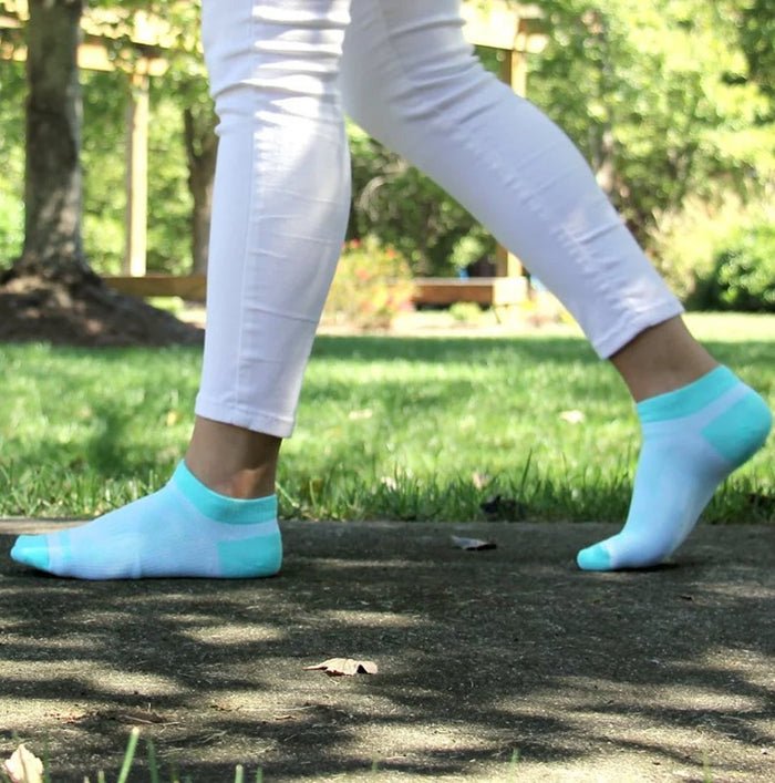 Person wearing light blue socks with white stripes in a park setting