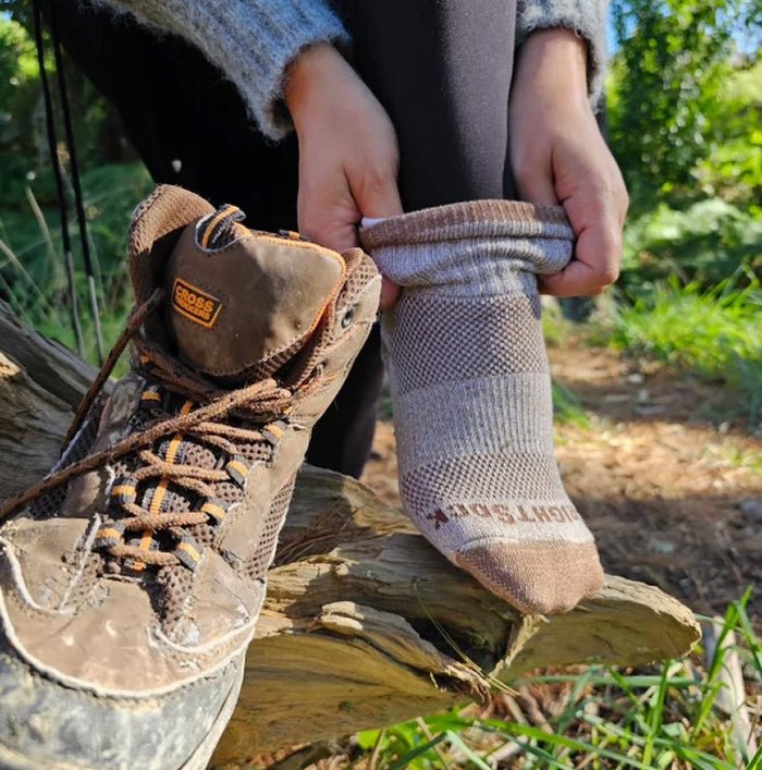 Person wearing a brown boot and matching sock outdoors