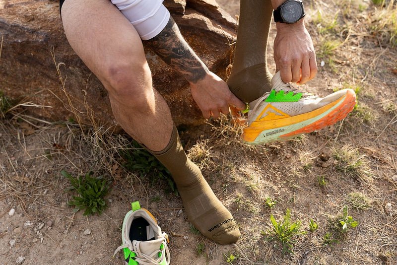 person wearing running shoes on trail